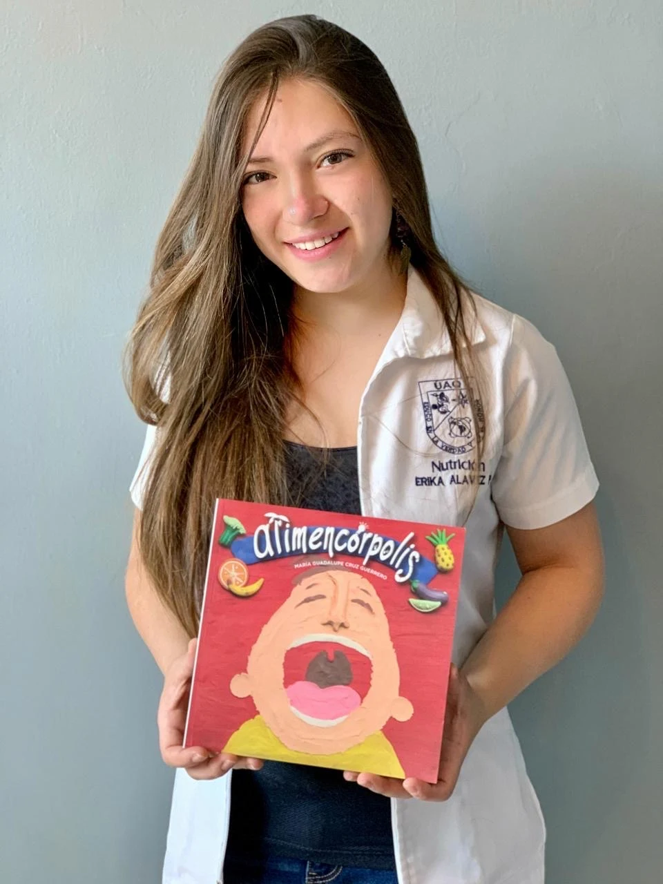 Erika Alavez con un libro de educación alimentaria